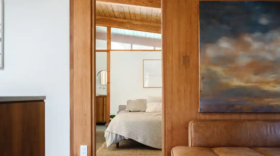 Bedroom with leather bench and landscape painting by Christa Martin, Bel Air