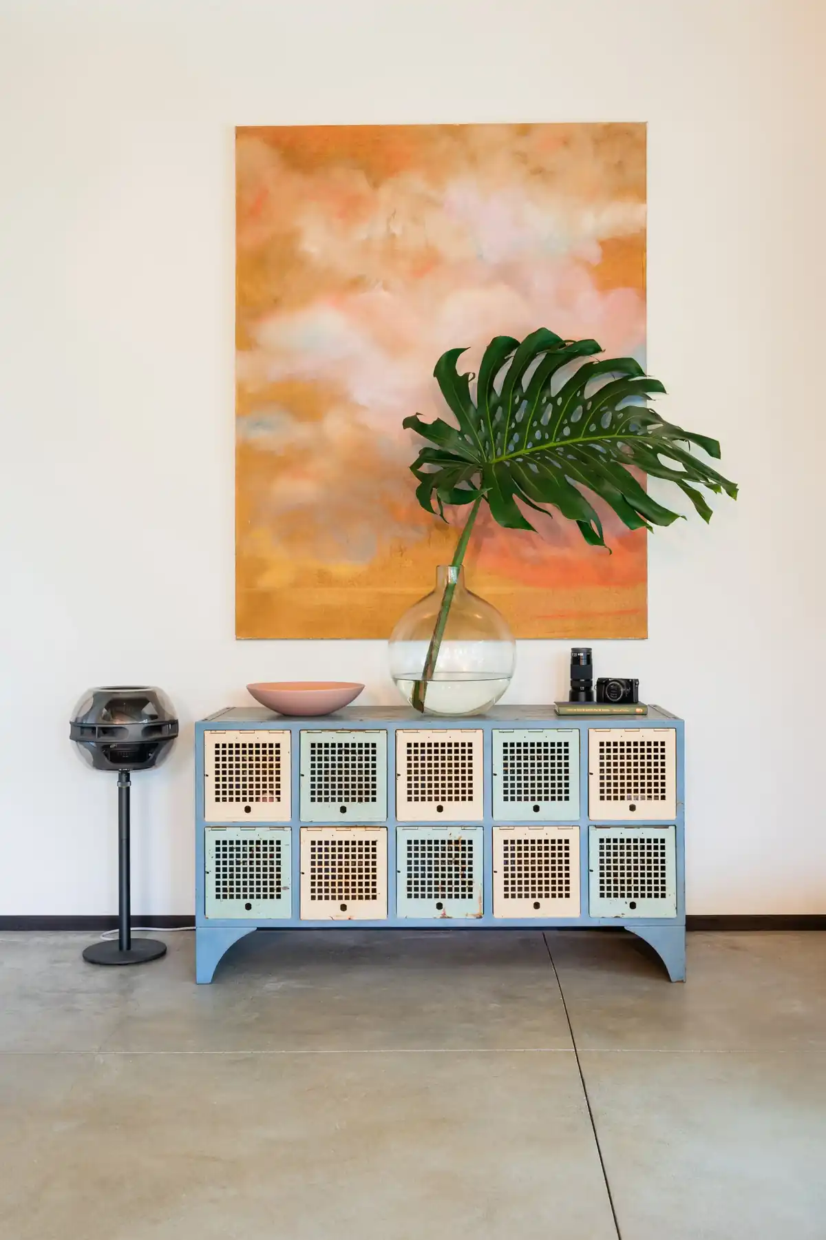 Interior with orange sky painting by Christa Martin and vintage blue cabinet, Princeville, Kauai