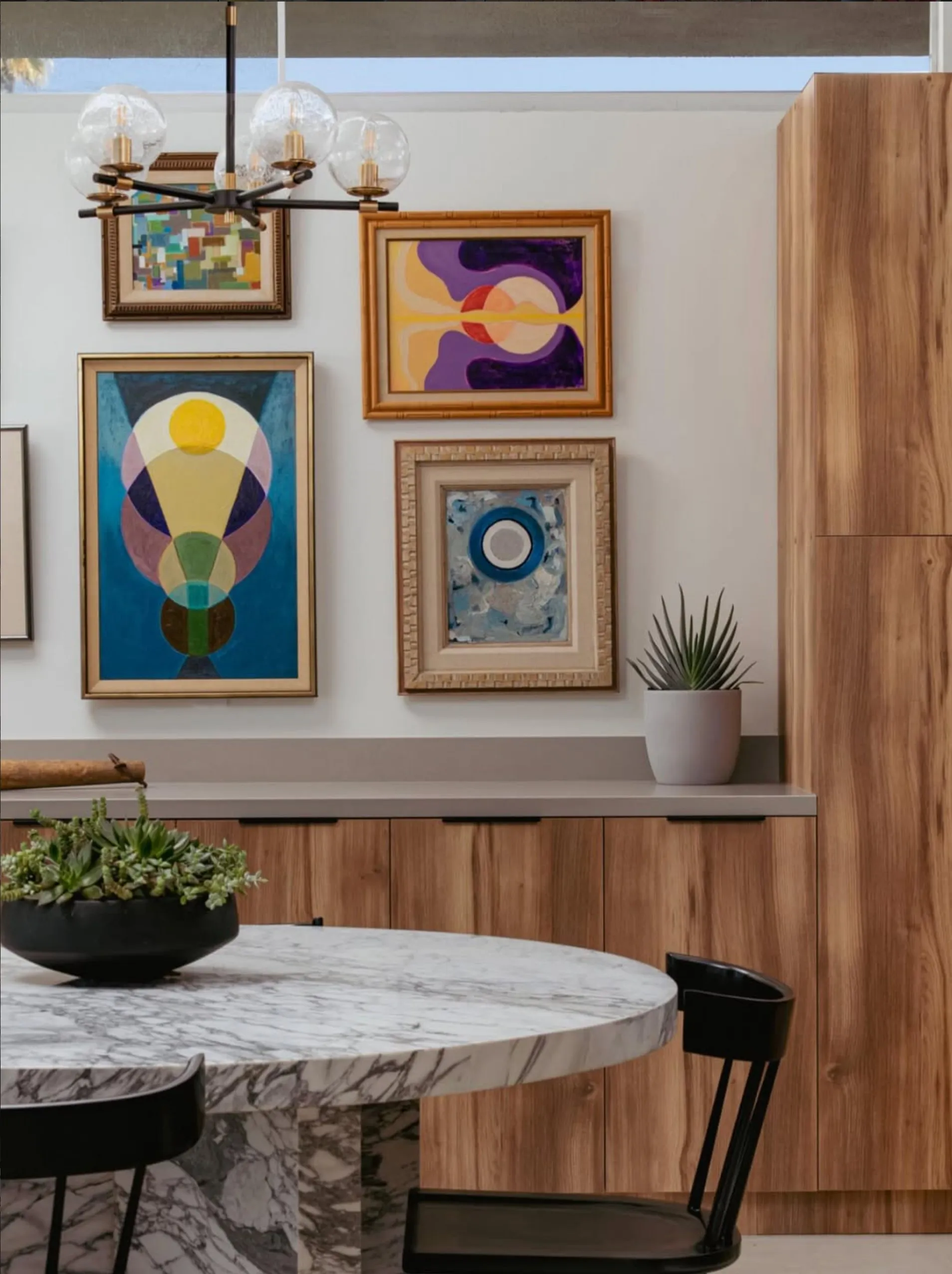 Gallery wall of four Lynda Keeler paintings above the dining credenza, 399 Desert Lakes Drive